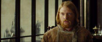 Movie still from “Anna Karenina” (2012), directed by Joe Wright – A man with long blonde hair and a beard; Close Up shot, Over the shoulder angle