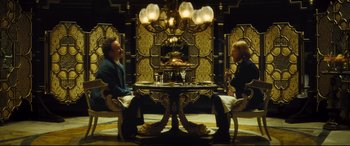 Movie still from “Anna Karenina” (2012), directed by Joe Wright – Two people sitting at a table in a room; Wide shot, High angle