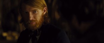 Movie still from “Anna Karenina” (2012), directed by Joe Wright – A person wearing a suit and tie; Close Up shot, Over the shoulder angle