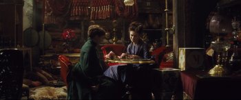 Movie still from “Anna Karenina” (2012), directed by Joe Wright – Two women sitting at a table in a room; Medium shot, High angle