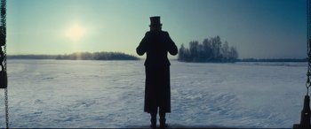 Movie still from “Anna Karenina” (2012), directed by Joe Wright – A man in a top hat standing in front of a snow covered field; Wide shot, Low angle