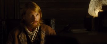 Movie still from “Anna Karenina” (2012), directed by Joe Wright – A man with long hair and a beard sitting in a chair; Close Up shot, Over the shoulder angle