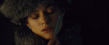 Movie still from “Anna Karenina” (2012), directed by Joe Wright – A woman is holding a pair of tweezers in her mouth; Close Up shot, Overhead angle