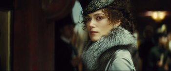 Movie still from “Anna Karenina” (2012), directed by Joe Wright – A person wearing a hat and a coat; Close Up shot, Over the shoulder angle