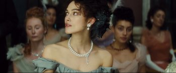 Movie still from “Anna Karenina” (2012), directed by Joe Wright – A woman wearing a pearl necklace and earrings; Close Up shot, Low angle