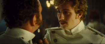 Movie still from “Anna Karenina” (2012), directed by Joe Wright – A person wearing a white jacket; Close Up shot, Over the shoulder angle