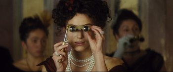 Movie still from “Anna Karenina” (2012), directed by Joe Wright – A woman holding a cell phone up to her eyes; Close Up shot, Over the shoulder angle