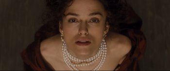 Movie still from “Anna Karenina” (2012), directed by Joe Wright – A person wearing a pearl necklace; Close Up shot, Overhead angle