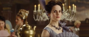 Movie still from “Anna Karenina” (2012), directed by Joe Wright – A woman in a purple dress and a feather necklace; Close Up shot, Low angle