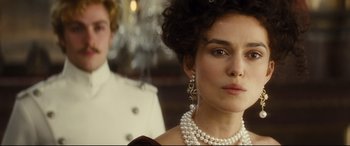 Movie still from “Anna Karenina” (2012), directed by Joe Wright – A person wearing a dress and pearls; Close Up shot, Over the shoulder angle