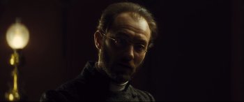 Movie still from “Anna Karenina” (2012), directed by Joe Wright – A person wearing glasses; Close Up shot, Low angle