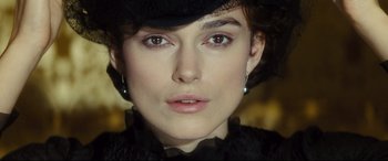 Movie still from “Anna Karenina” (2012), directed by Joe Wright – A person wearing a hat and looking at the camera; Close Up shot, Over the shoulder angle
