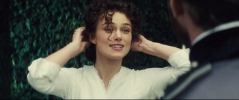 Movie still from “Anna Karenina” (2012), directed by Joe Wright – A young woman with her hands in her hair; Close Up shot, Over the shoulder angle