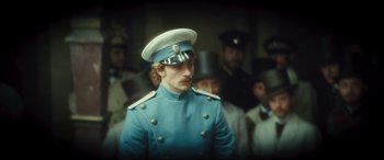 Movie still from “Anna Karenina” (2012), directed by Joe Wright – A man in a blue uniform and a white hat; Medium shot, Low angle