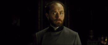 Movie still from “Anna Karenina” (2012), directed by Joe Wright – A man with a goatee wearing glasses and a suit; Close Up shot, Low angle