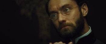 Movie still from “Anna Karenina” (2012), directed by Joe Wright – A person wearing glasses and a beard; Close Up shot, Low angle