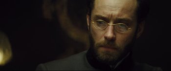 Movie still from “Anna Karenina” (2012), directed by Joe Wright – A person wearing glasses; Close Up shot, Over the shoulder angle