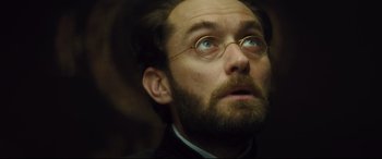 Movie still from “Anna Karenina” (2012), directed by Joe Wright – A person with a beard wearing glasses; Close Up shot, Low angle
