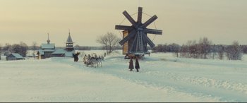 Movie still from “Anna Karenina” (2012), directed by Joe Wright – A group of people standing in the snow next to a windmill; Extreme Wide shot, Low angle