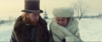 Movie still from “Anna Karenina” (2012), directed by Joe Wright – A man and a woman wearing fur coats and hats; Medium shot, Over the shoulder angle