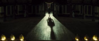 Movie still from “Anna Karenina” (2012), directed by Joe Wright – A person walking down a hallway with a light shining on them; Extreme Wide shot, Low angle