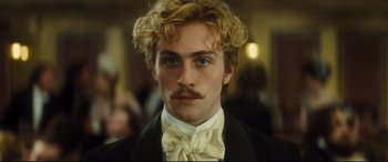 Movie still from “Anna Karenina” (2012), directed by Joe Wright – A person wearing a suit and a bow tie; Close Up shot, Low angle