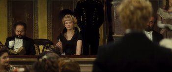 Movie still from “Anna Karenina” (2012), directed by Joe Wright – A woman sitting at a table in front of a man in a uniform; Medium shot, Over the shoulder angle