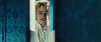 Movie still from “Anna Karenina” (2012), directed by Joe Wright – A man in a white suit and a white bow tie looking into a mirror; Close Up shot, Over the shoulder angle