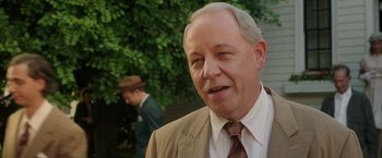 Movie still from “Annabelle: Creation” (2017), directed by David F. Sandberg – An older man wearing a suit and tie; Close Up shot, Over the shoulder angle