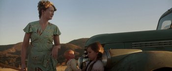 Movie still from “Annabelle: Creation” (2017), directed by David F. Sandberg – A woman and a child standing in front of an antique car; Medium shot, Low angle