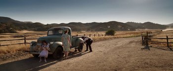 Movie still from “Annabelle: Creation” (2017), directed by David F. Sandberg – A man and a woman looking at an old truck; Wide shot, High angle