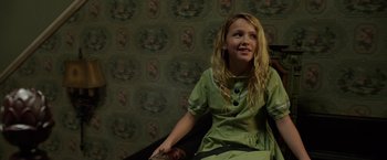 Movie still from “Annabelle: Creation” (2017), directed by David F. Sandberg – A young girl sitting on a chair in a room; Medium shot, High angle