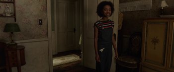 Movie still from “Annabelle: Creation” (2017), directed by David F. Sandberg – A young girl standing in a doorway smiling; Medium shot, Over the shoulder angle