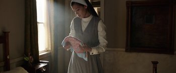 Movie still from “Annabelle: Creation” (2017), directed by David F. Sandberg – A woman in a nun's outfit reading a book; Medium shot, Low angle