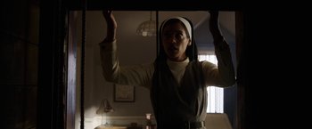 Movie still from “Annabelle: Creation” (2017), directed by David F. Sandberg – A woman wearing a nun's outfit in a dark room; Medium shot, Low angle