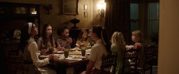 Movie still from “Annabelle: Creation” (2017), directed by David F. Sandberg – A group of people sitting at a table eating food; Medium shot, High angle
