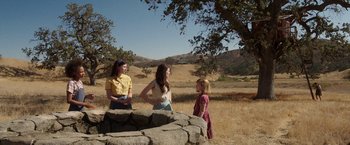 Movie still from “Annabelle: Creation” (2017), directed by David F. Sandberg – Three young women standing next to each other in a field; Wide shot, High angle