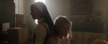 Movie still from “Annabelle: Creation” (2017), directed by David F. Sandberg – A nun standing next to a young girl in a room; Close Up shot, Low angle