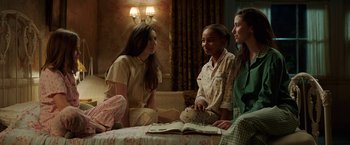 Movie still from “Annabelle: Creation” (2017), directed by David F. Sandberg – A group of young women sitting on a bed talking to each other; Medium shot, High angle