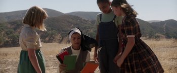 Movie still from “Annabelle: Creation” (2017), directed by David F. Sandberg – A woman in a nun's outfit reading a book to two young girls; Medium shot, High angle