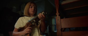 Movie still from “Annabelle: Creation” (2017), directed by David F. Sandberg – A young girl holding an old gun in a room; Close Up shot, Low angle