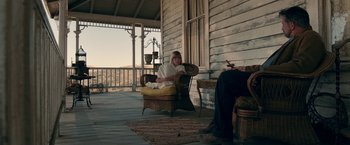 Movie still from “Annabelle: Creation” (2017), directed by David F. Sandberg – A woman sitting in a chair on a porch; Wide shot, Low angle