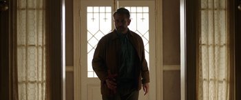 Movie still from “Annabelle: Creation” (2017), directed by David F. Sandberg – A man standing in front of a door holding a wooden cross; Medium shot, Low angle