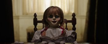 Movie still from “Annabelle: Creation” (2017), directed by David F. Sandberg – A creepy doll sitting in a wooden chair; Close Up shot, Over the shoulder angle