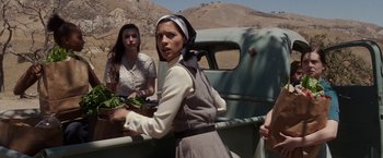 Movie still from “Annabelle: Creation” (2017), directed by David F. Sandberg – A woman holding a bunch of vegetables in a truck; Medium shot, Low angle
