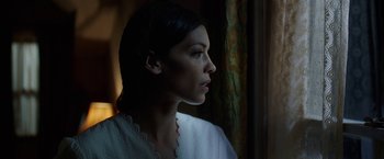 Movie still from “Annabelle: Creation” (2017), directed by David F. Sandberg – A beautiful young lady looking out a window at night; Close Up shot, Low angle