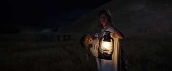 Movie still from “Annabelle: Creation” (2017), directed by David F. Sandberg – A little girl holding a lantern and a doll; Medium shot, Low angle