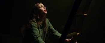 Movie still from “Annabelle: Creation” (2017), directed by David F. Sandberg – A woman in a green shirt is playing the piano; Medium shot, Low angle