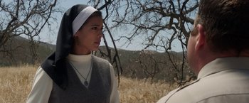 Movie still from “Annabelle: Creation” (2017), directed by David F. Sandberg – A woman wearing a nun's hat standing next to a tree; Close Up shot, Low angle