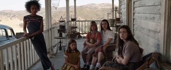 Movie still from “Annabelle: Creation” (2017), directed by David F. Sandberg – A group of people sitting on top of a wooden deck; Wide shot, High angle